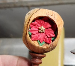 Cross drilled ornament with red flower decoration